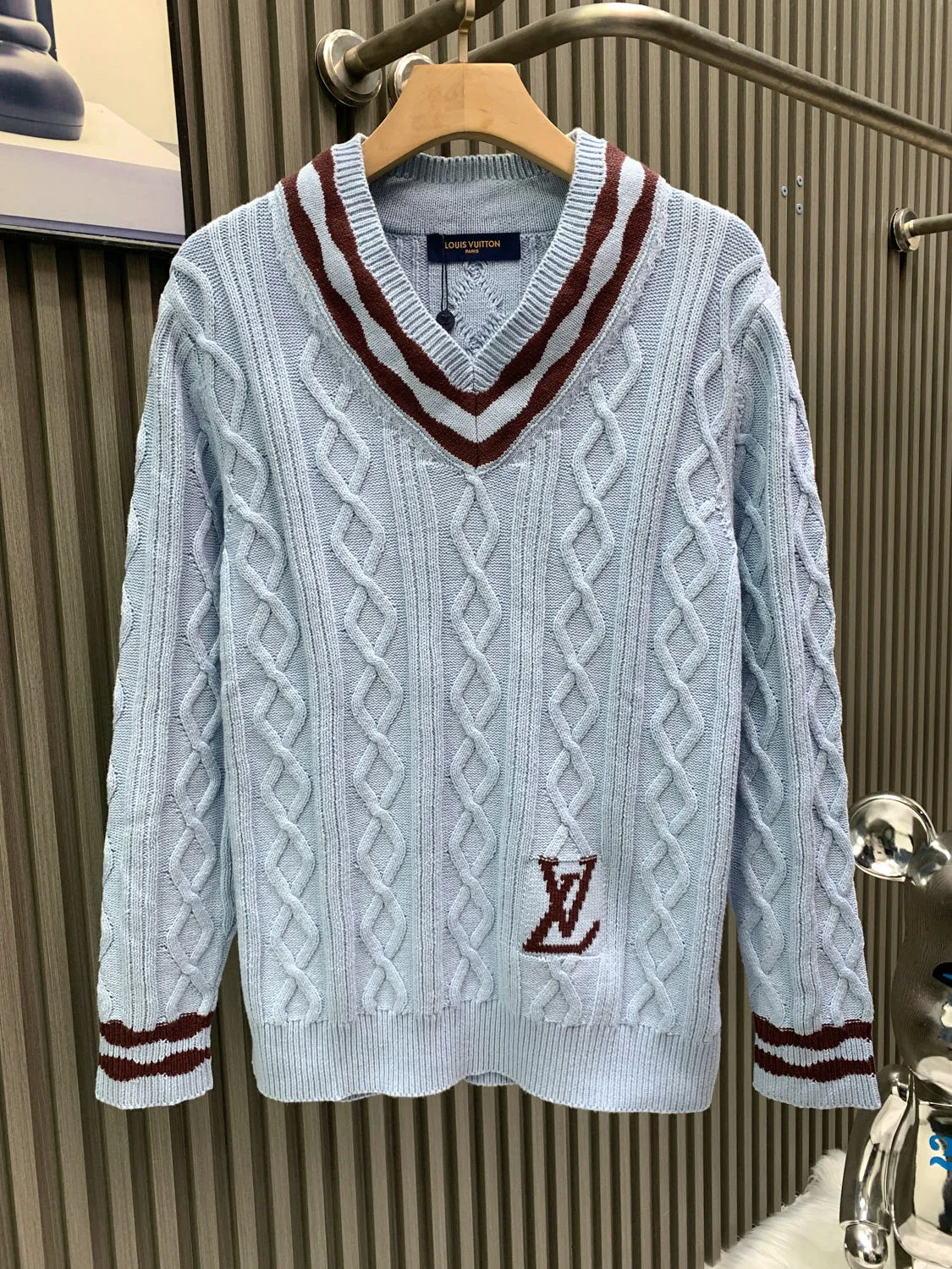 🅿️380 🀄️ Louis Vuitton 25* new autumn and winter cable knitted sheep wool and mohair V-neck pullover This cable knitted V-neck sweater is made of fine mohair and sheep wool, making the scalloped hem of the sleeves complement the wavy intarsia lines on the cuffs and collar. The contrasting 1V intarsia hem on the left adds a college atmosphere to the early spring look. Made of blended wool yarn, 30% wool and 70% acrylic dyed yarn. The process is complex and requires 180 points/piece. This style uses 7-needle Juxin woven pieces. 9 yarn feeders are needed to hang the wool on the front. The whole piece is moved to twist the rope. The intersection of the twisted ropes is prone to holes. The coffee-colored part of the yarn is mohair. The machine adjustment time is long. The needles added at the bottom of the sleeve clips are all edged, which increases the loom time and sewing time. Because the logo is hung with hair, the coffee-colored thread is clamped on the edge and needs to be drawn out. Moreover, due to the characteristics of mohair, hair will fall out when drawing out the thread. It is necessary to manually remove the stray hairs bit by bit, which is very time-consuming. Customized accessories, complete with three standards, same style for men and women.